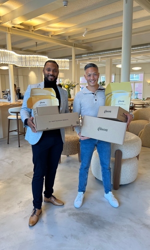 Onze accountmanager met iemand van Gisou die dozen vast houden.